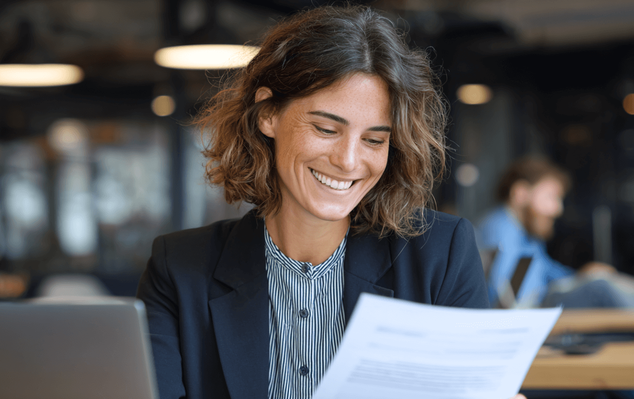 smiling attorney holding loan approval papers in office 